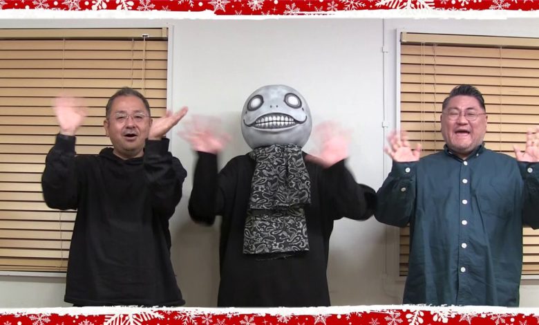 NieR series producer Keiichi Okabe, music producer Yosuke Saito, and creative director Yoko Taro waving at the screen