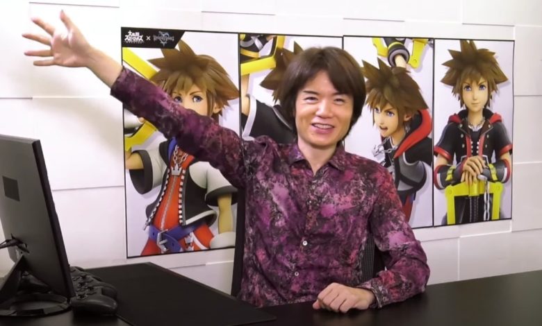 Masahiro Sakurai sitting at a desk in front of a wall with different pictures of Sora